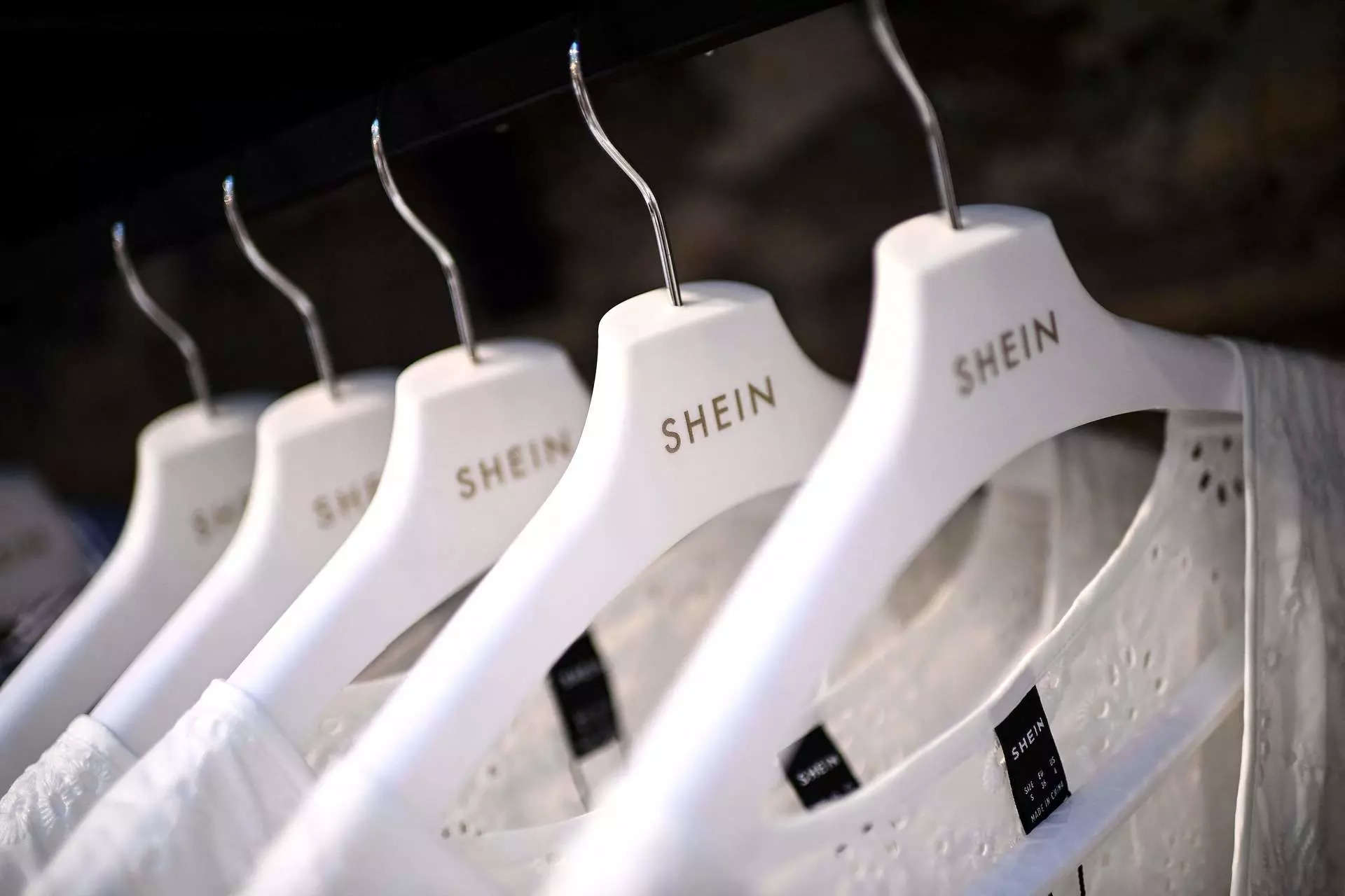 <p>Clothes are displayed on hangers at a Chinese fashion brand Shein pop-up store in Paris on May 4, 2023. The Shein pop-up store is set to open for business from May 5 to 8. (Photo by Christophe ARCHAMBAULT / AFP)</p>