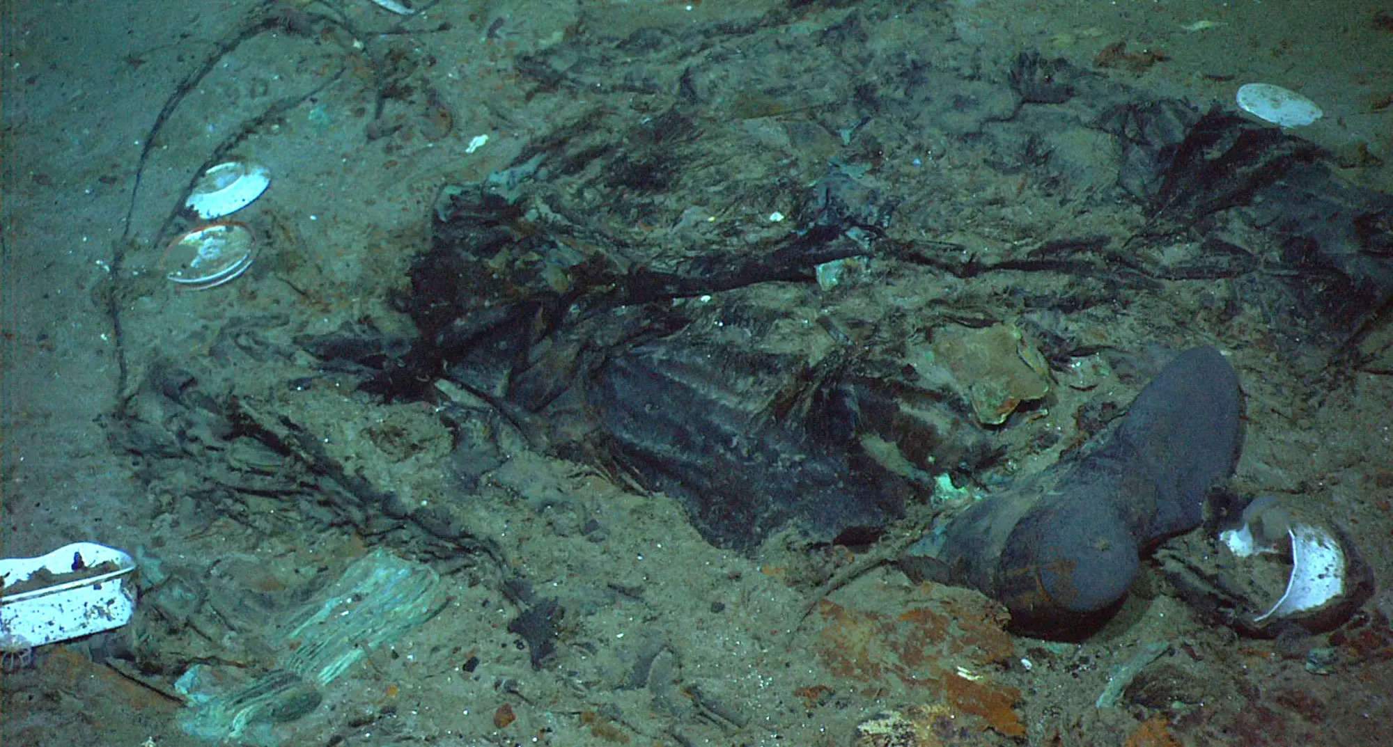 <p>FILE - This 2004 photo provided by the Institute for Exploration, Center for Archaeological Oceanography/University of Rhode Island/NOAA Office of Ocean Exploration, shows the remains of a coat and boots in the mud on the sea bed near the Titanic's stern. The wrecks of the Titanic and the Titan sit on the ocean floor, separated by 1,600 feet (490 meters) and 111 years of history. How they came together unfolded over an intense week that raised temporary hopes and left lingering questions. (Institute for Exploration, Center for Archaeological Oceanography/University of Rhode Island/NOAA Office of Ocean Exploration, File)</p>