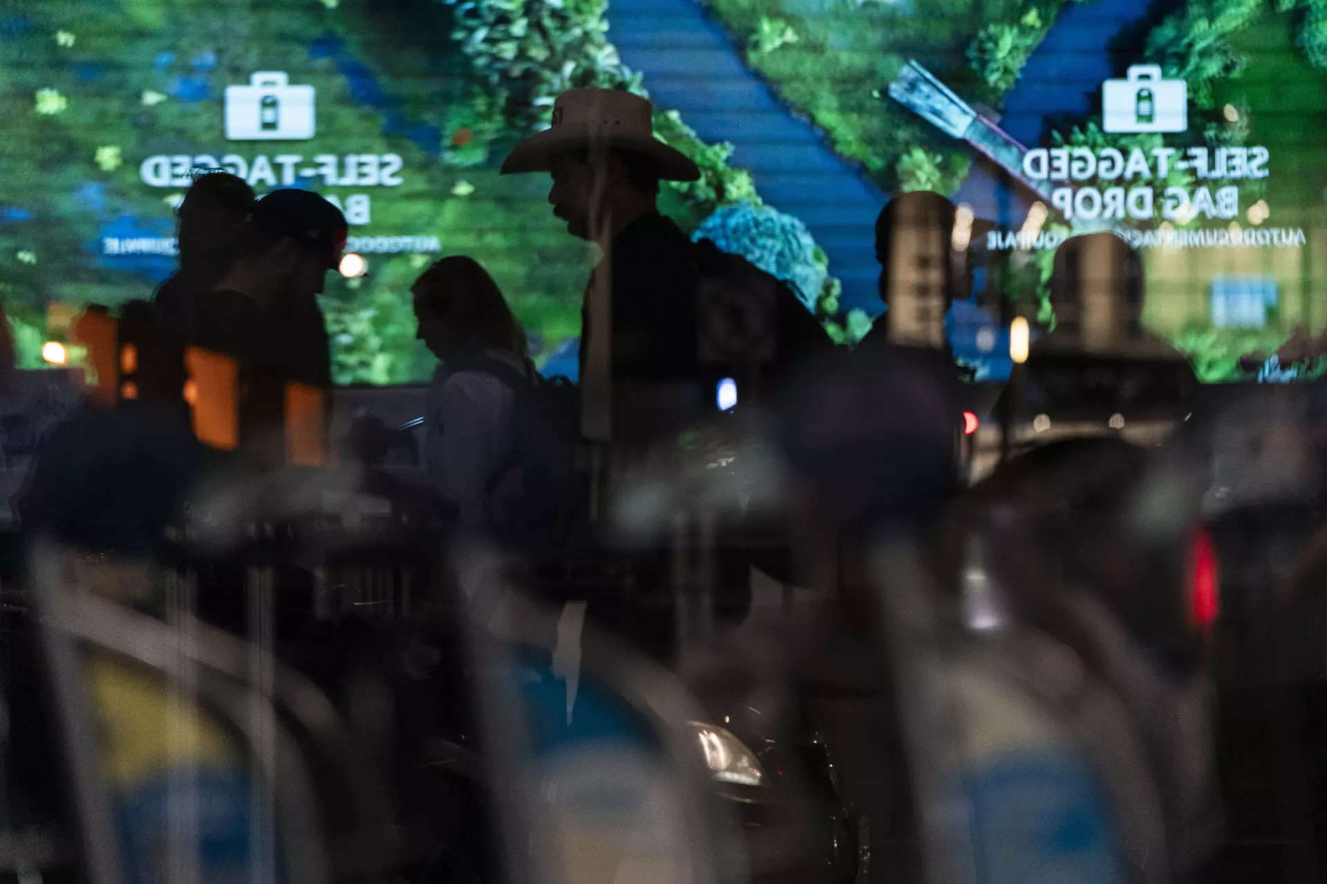 <p>Travelers are reflected on a glass wall as they stand in a ticketing area at the Los Angeles International Airport in Los Angeles, Friday, Sept. 1, 2023.</p>