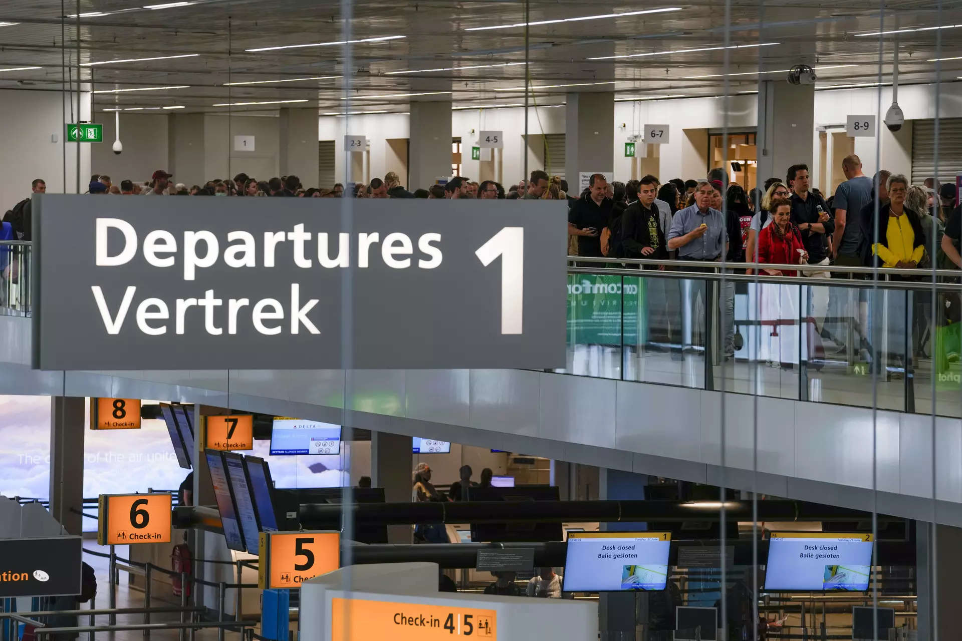 <p>FILE - Travelers wait in long lines to check in and board flights at Amsterdam's Schiphol Airport, Netherlands, on June 21, 2022.</p>