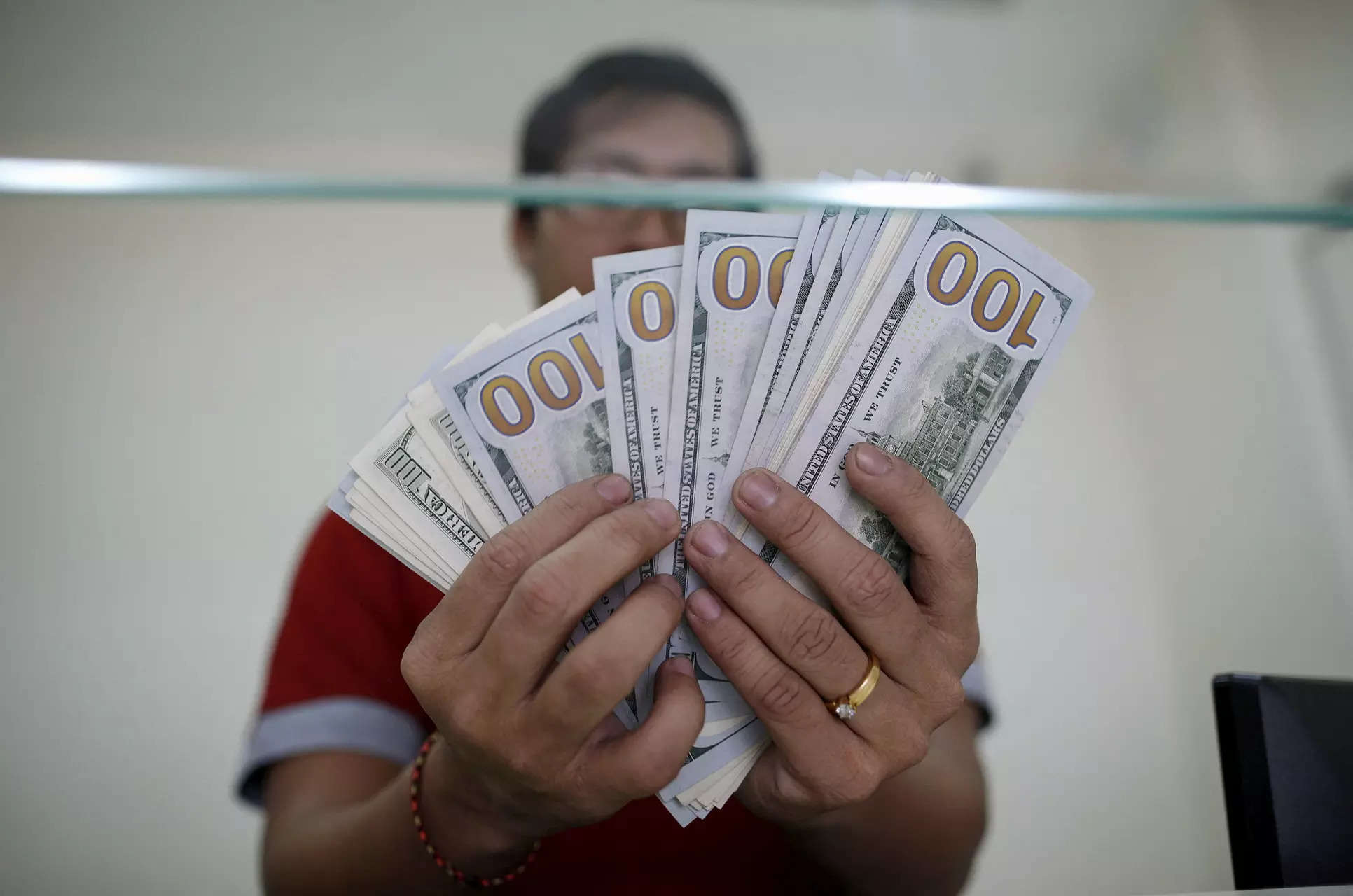 <p>FILE PHOTO: Bank staff shows U.S. hundred dollars bills at AYA Bank's money changer in Yangon July 17, 2015. REUTERS/Soe Zeya Tun/File Photo</p>