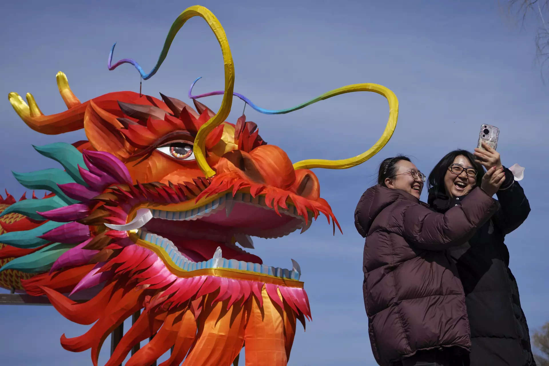<p>Women take a selfie with a giant dragon lantern decorated near the frozen Houhai Lake in Beijing.</p>