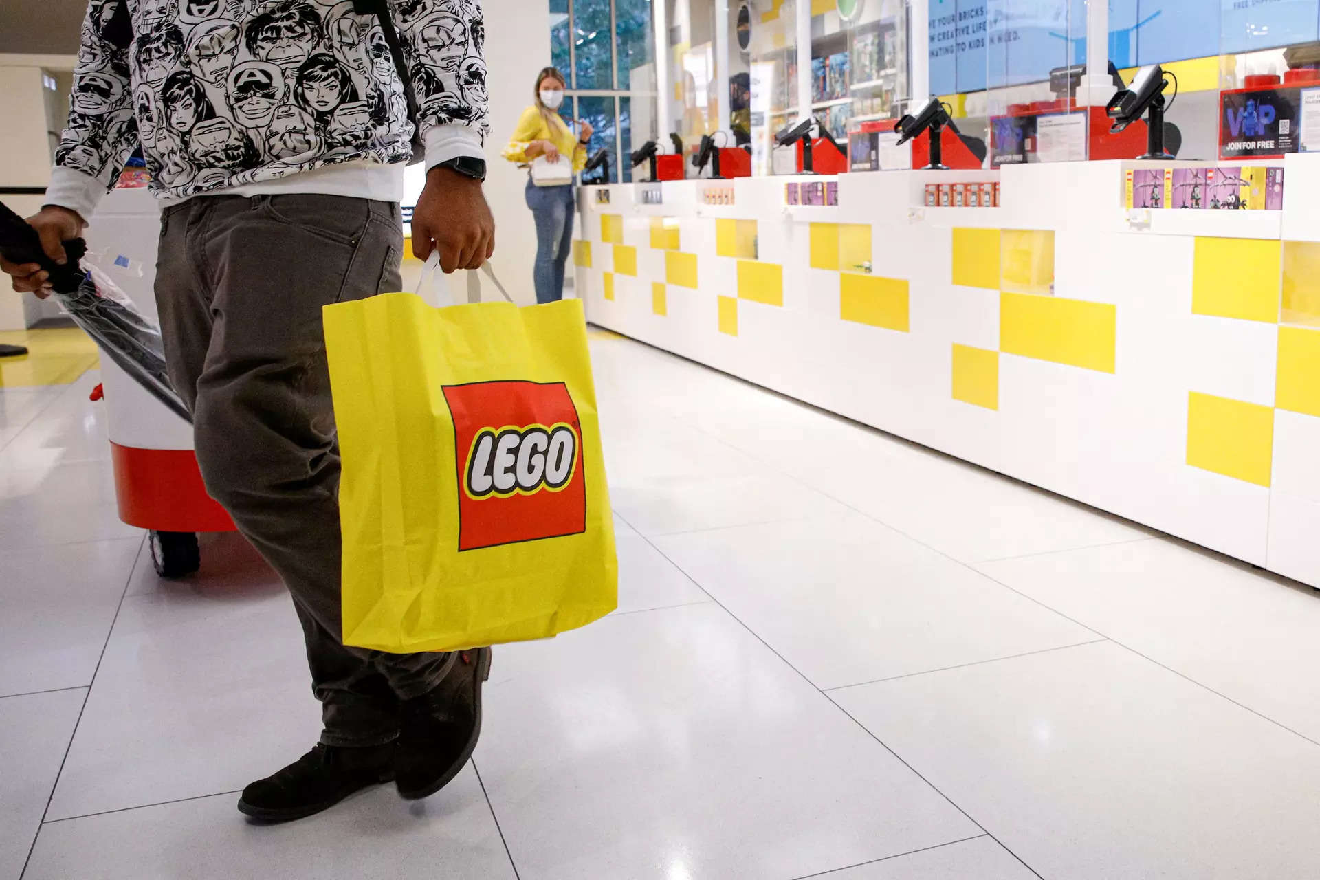 <p>FILE PHOTO: A customer carries a bag while shopping in the 5th Avenue Lego store in New York City, U.S., September 28, 2021.  REUTERS/Brendan McDermid/File Photo</p>