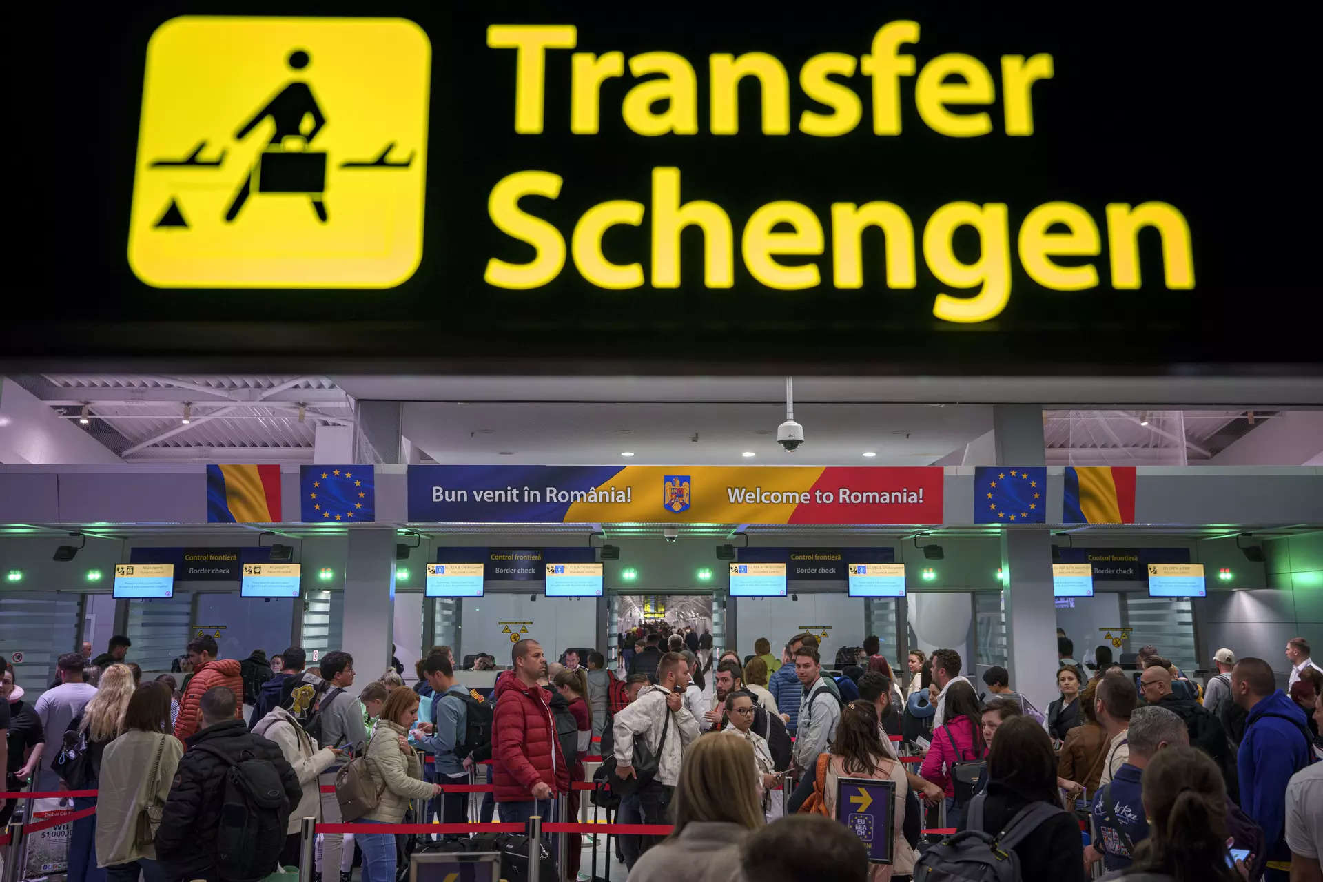 <p>Passengers arriving at the Henri Coanda International Airport pass under a Schengen Information sign, in Otopeni, near Bucharest, Romania, Sunday, March 31, 2024.</p>