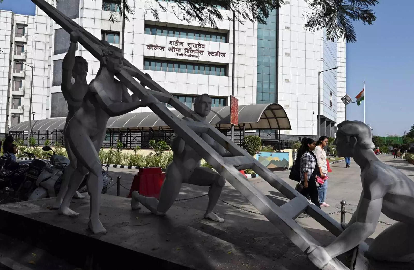 <p>At the entrance is a sculpture depicting a man attempting to climb a ladder, with several figures at the base holding it steady</p>