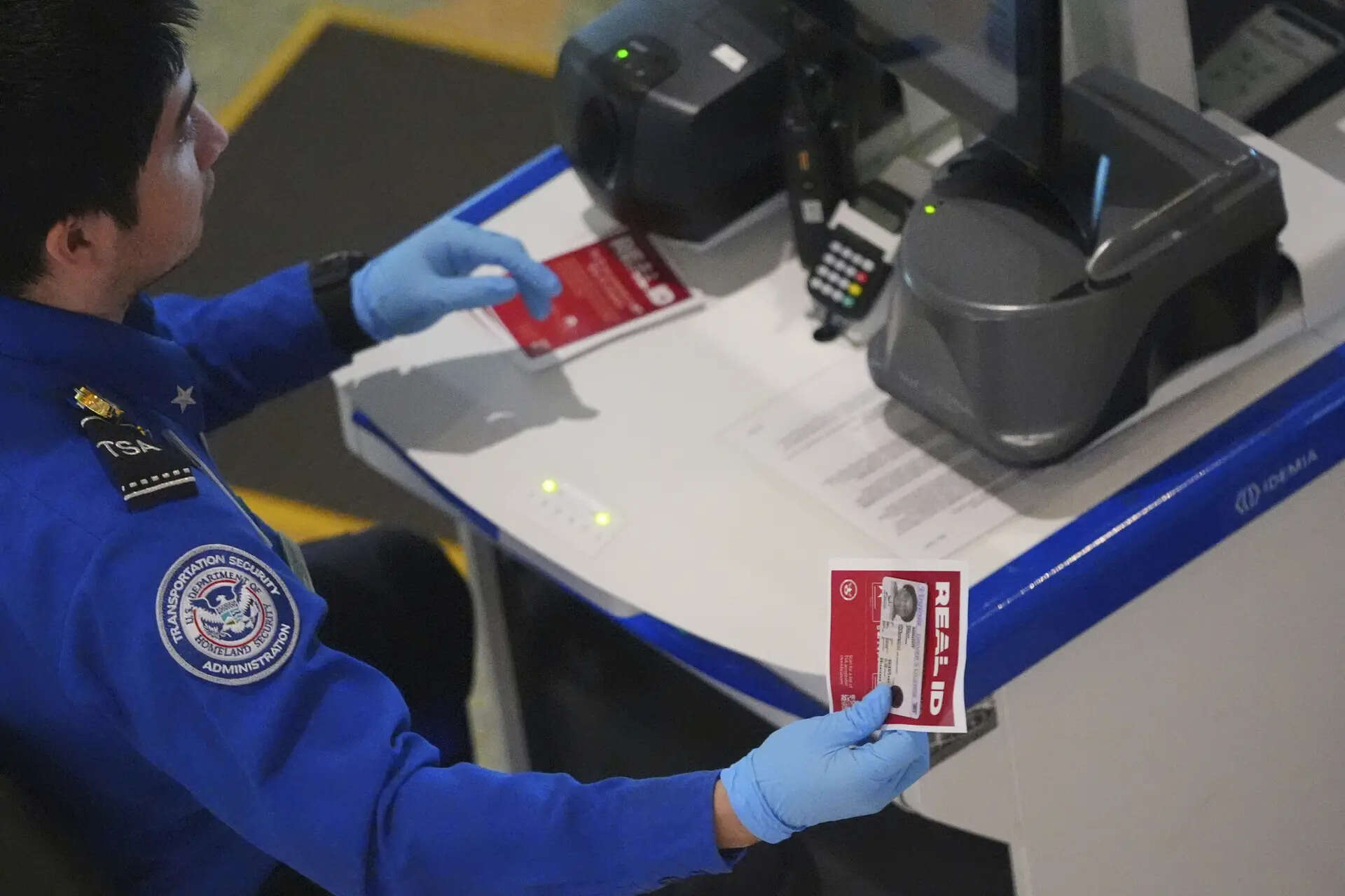 <p>A TSA agent hands off a non-Real ID for a traveler passing through security at Love Field airport in Dallas, Wednesday, May 7, 2025. (AP Photo/LM Otero)</p>