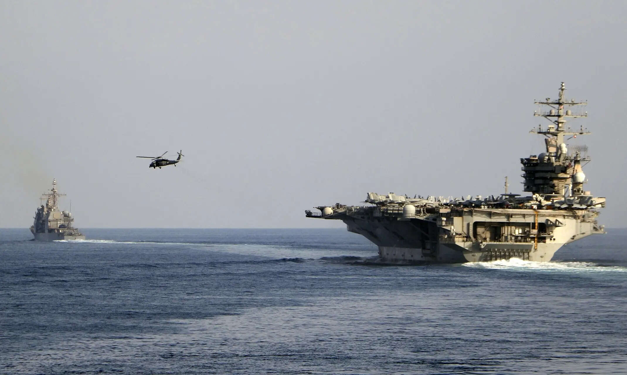 <p>The aircraft carrier USS Dwight D. Eisenhower and other warships crosses the Strait of Hormuz, which is a vital route for oil, into the Persian Gulf.</p>