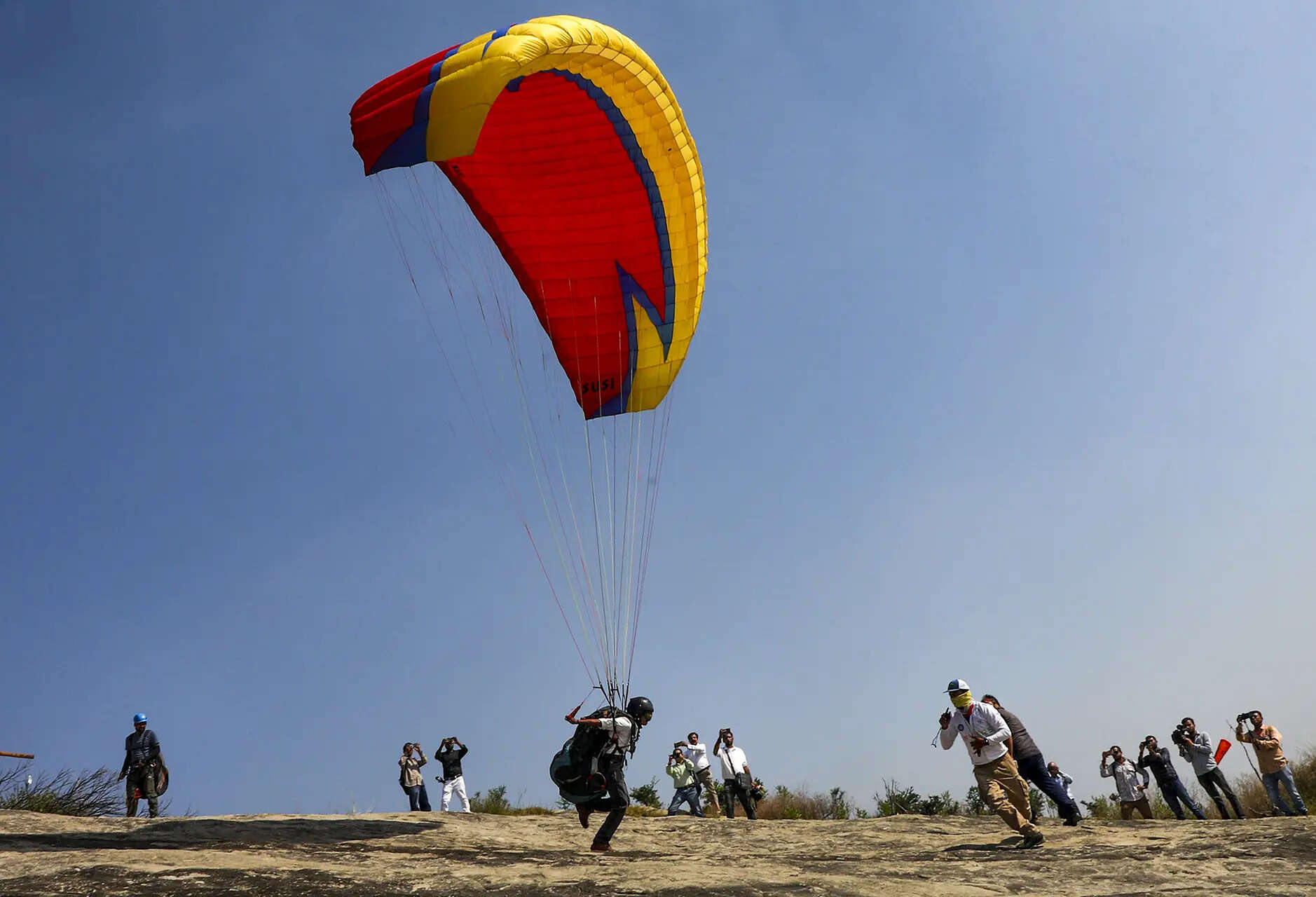 <p>A paragliding pilot takes part in a paragliding refresher course by Directorate of Tourism, at Aithem View Point, Jammu-Surinsar Road. </p>