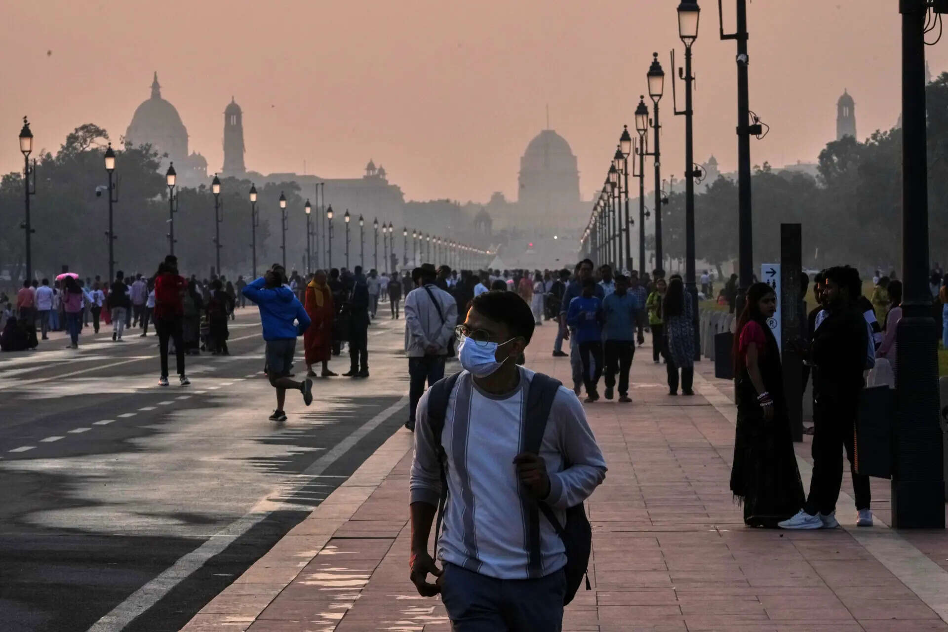 A person walks wearing a face mask to fight air pollution in the capital city New Delhi, India, Sunday, Nov. 9, 2025.