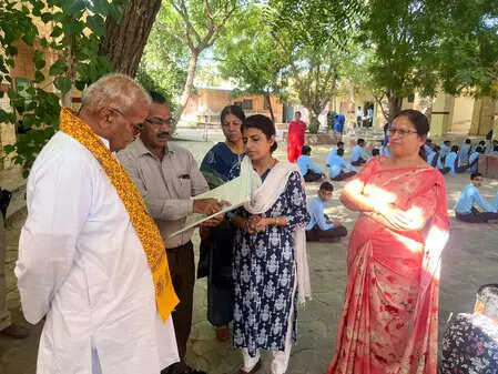 <p>Standing quietly behind the students, the Minister observed the proceedings before joining the children in reciting the national anthem</p>