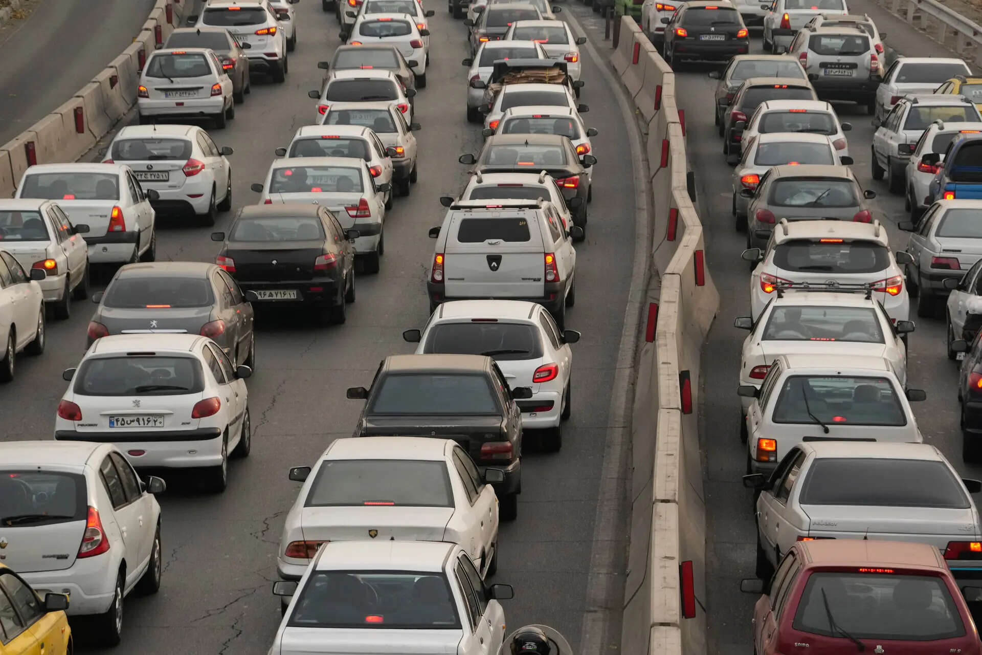 Cars drive in an afternoon traffic jam in a high air pollution in Tehran, Iran, Sunday, Dec. 7, 2025. (AP Photo/Vahid Salemi)
