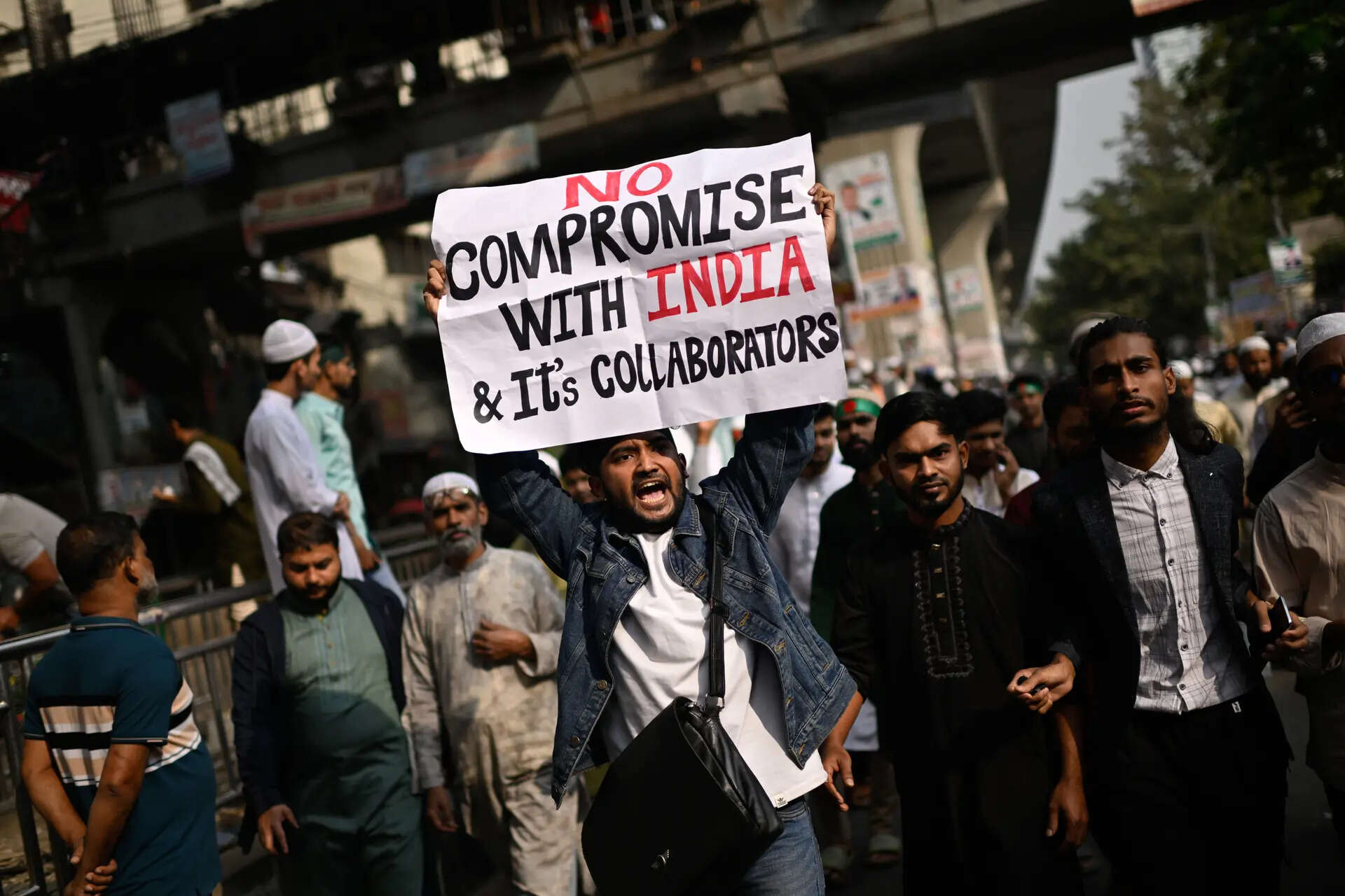 <p>A protester holds a placard and shout slogans during a protest following overnight attacks and vandalism after the death of a prominent activist</p>