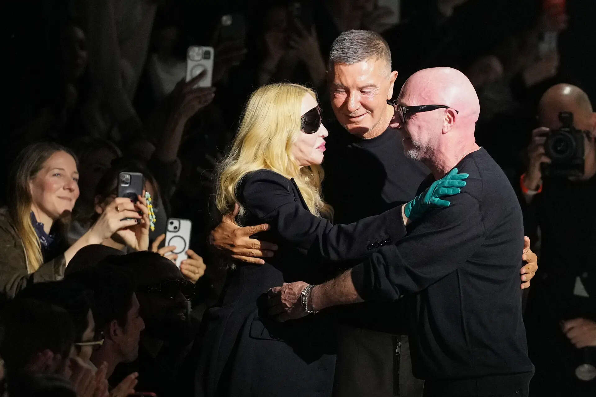 FILE -Madonna congratulates Domenico Dolce, right, and Stefano Gabbana at the end of the Dolce & Gabbana Fall/Winter 2026-2027 Womens collection, presented in Milan, Italy, Feb. 28, 2026. (AP Photo/Antonio Calanni), File)