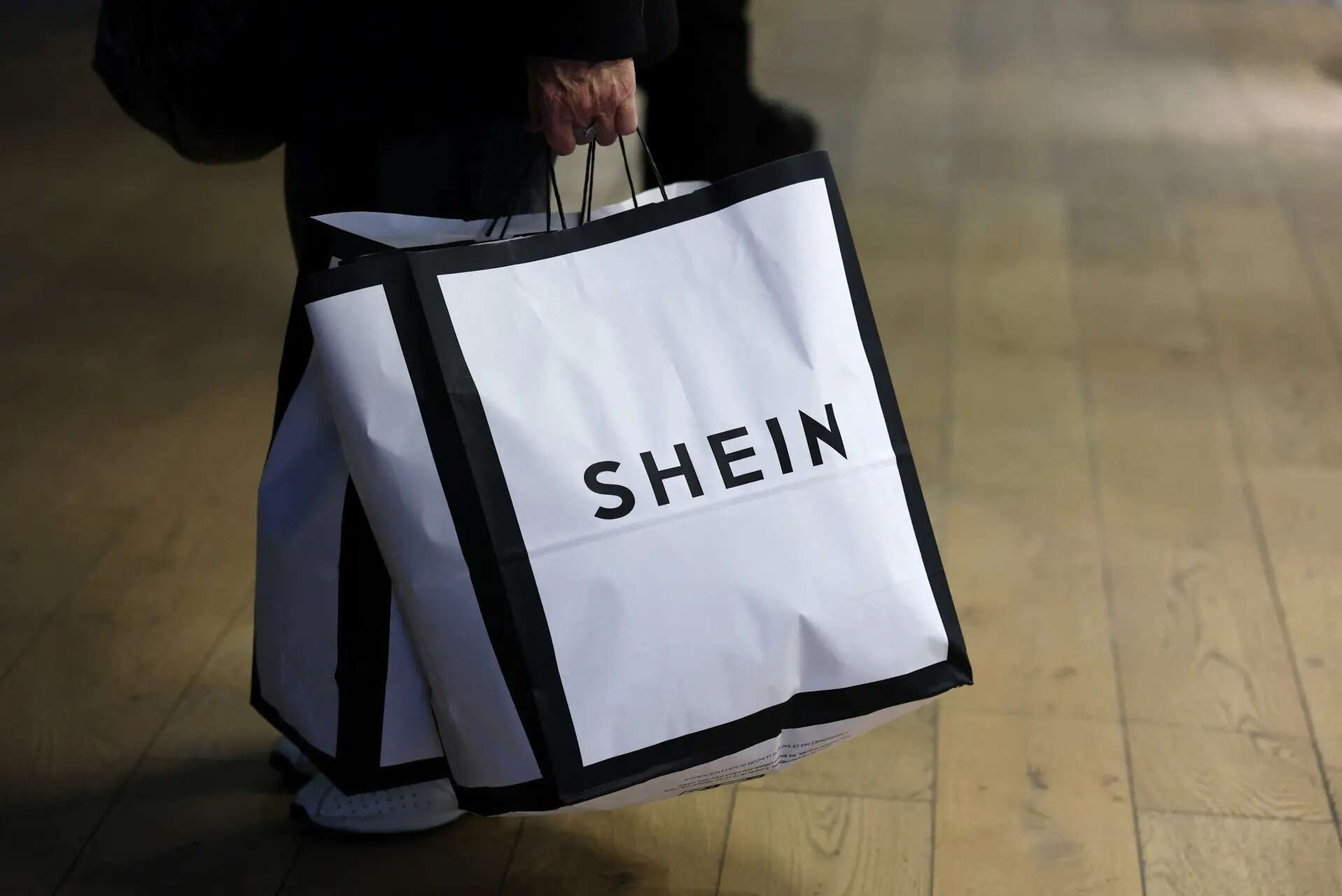 A customer holds shopping bags with a Shein logo in the first physical space of Chinese online fast-fashion retailer Shein on the day of its opening inside the Le BHV Marais department store, the Bazar de lHotel de Ville, in Paris, France, November 5, 2025. REUTERS/Sarah Meyssonnier/File Photo