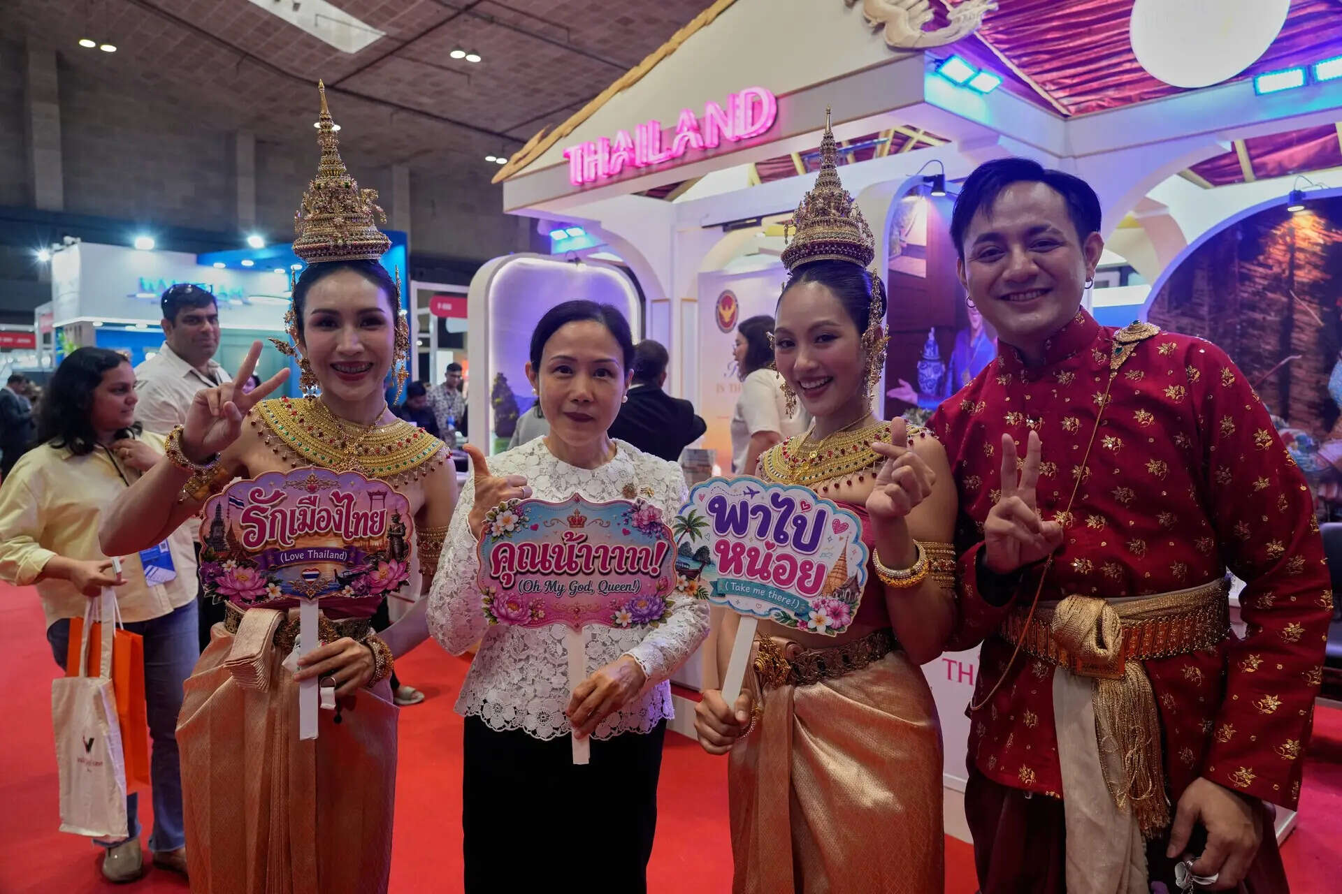 Khun Siriporn Tantipanyathep, left, Consulate General of Thailand pose with the artists at Thailand stall at Travel & Tourism Fair in Kolkata, India, Friday, July 10, 2026. (AP Photo/Bikas Das)