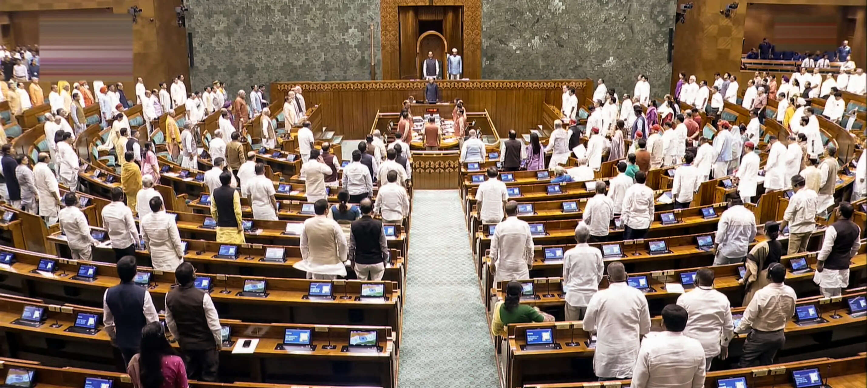 Members of Parliament stand at attention during the rendition of Vande Mataram in Lok Sabha during the Monsoon session of Parliament, in New Delhi.