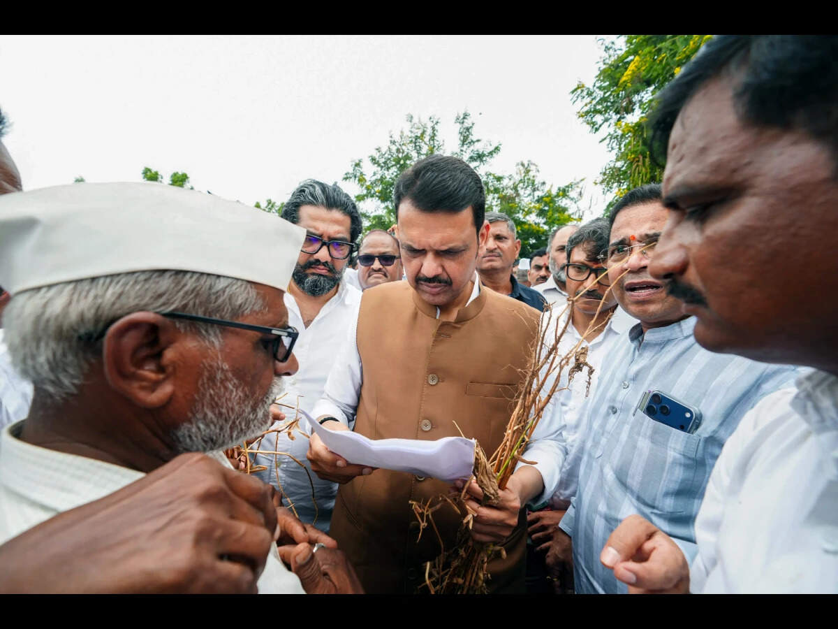 Maharashtra Chief Minister Devendra Fadnavis reviews a memorandum submitted by local farmers while inspecting drought-affected agricultural lands in Latur