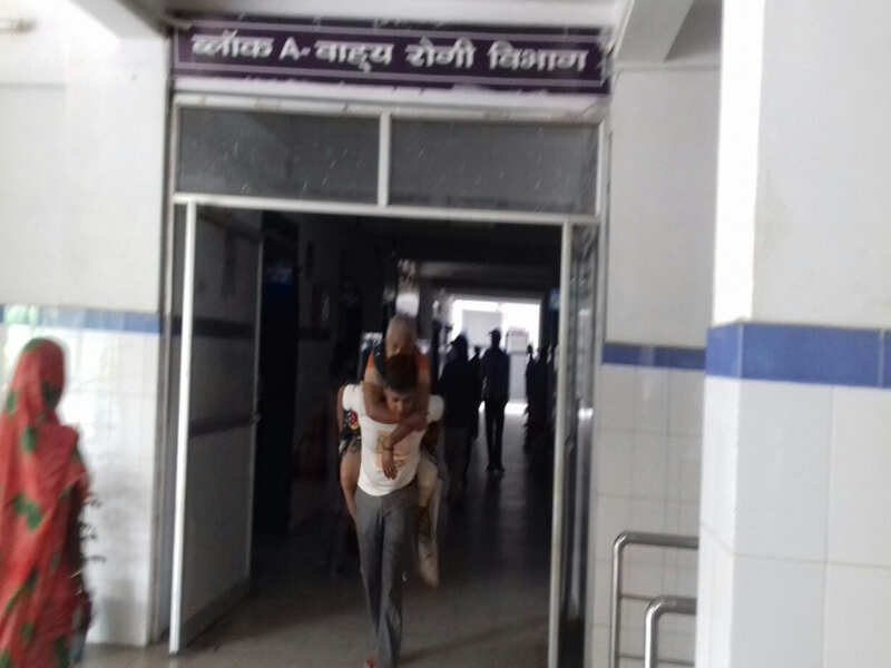 Vijay Kumar carries his mother on his back at Buxar hospital.