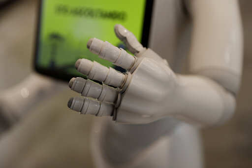 Robot Robby Pepper's hand is seen in the foreground as it welcomes guests at the front desk of hotel in Peschiera del Garda, northern Italy, Monday, March 12, 2018. Robby Pepper, billed as Italy's first robot concierge, has been programed to answer simple guest questions in Italian, English and German, the humanoid, speaking robot will be deployed all season at a hotel on the popular Garda Lake to help relieve the desk staff of simple, repetitive questions.Photo/Luca Bruno)