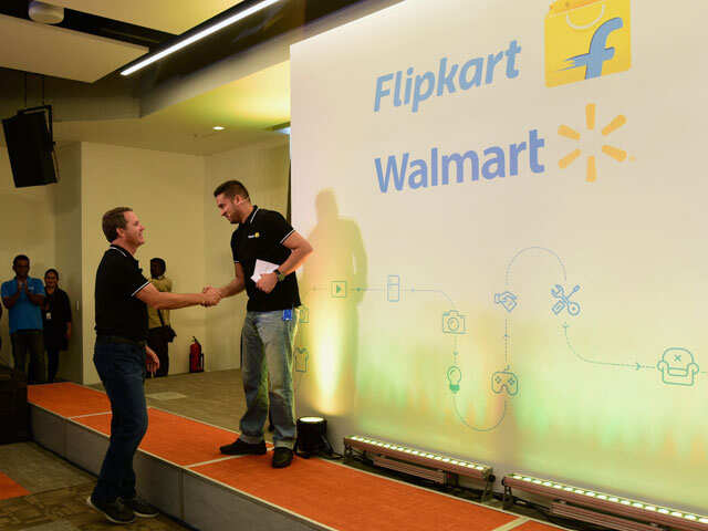 This photo taken on May 9, 2018 shows Walmart CEO Doug McMillon (L) and Flipkart co-founder and CEO Binny Bansal shaking hands at an event in Bangalore, as a deal was announced for Walmart to buy a stake in Flipkart.