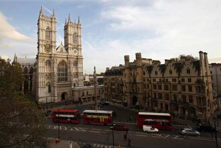 London buses drive past Westminster Abbey in London. The city has more than $8 billion at risk, placing it ninth in the Lloyd's City Risk Index, with a market crash its biggest threat. REUTERS/Suzanne Plunkett/File Photo