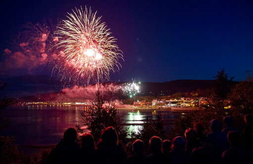 Residents watch fireworks explode over La Malbaie, Quebec, after the G7 leaders summit on Saturday, June 9, 2018. (Justin Tang/The Canadian Press via AP)