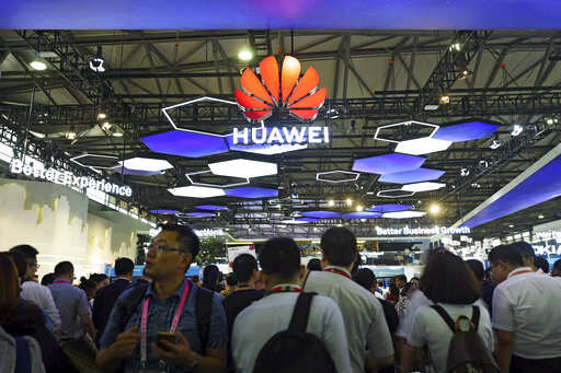 Visitors tour the Huawei exhibition booth during the Mobile World Congress in Shanghai, China, Wednesday, June 27, 2018. A Huawei executive says Australia could damage its economic future if it bans the Chinese telecommunication giant from the nation's next-generation mobile network technology. (Chinatopix via AP)