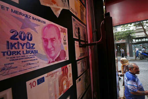 An oversized copy of a 200 Turkish lira banknote, featuring a photo of modern Turkey's founder Mustafa Kemal Ataturk decorates a currency exchange shop in Istanbul, Friday, Aug. 17, 2018. Turkey and the United States exchanged new threats of sanctions Friday, keeping alive a diplomatic and financial crisis.Photo/Lefteris Pitarakis)