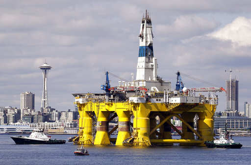 FILE - In this May 14, 2015, file photo, the oil drilling rig Polar Pioneer is towed toward a dock in Elliott Bay in Seattle. Sharply lower oil prices are sending ripples through the global economy, lending more spending power to consumers _ particularly for Americans' big holiday shopping spree _ but potentially dampening investment in U.S. oil production.Photo/Elaine Thompson, File)