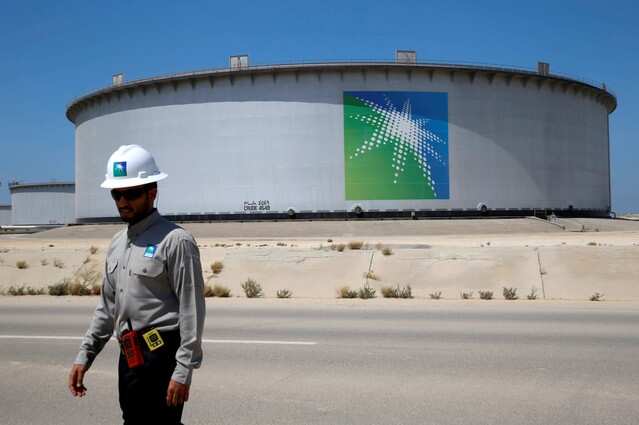 An Aramco employee walks near an oil tank at Saudi Aramco's Ras Tanura oil refinery and oil terminal in Saudi Arabia, May 21, 2018. Picture taken May 21, 2018. REUTERS/Ahmed Jadallah/File Photo