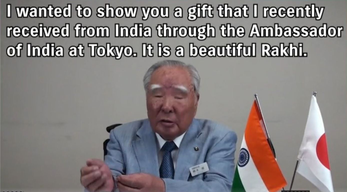 Suzuki Motor Corporation Chairman Osamu Suzuki showing off the Rakhi he received from the Ambassador of India to Tokyo at an ACMA event.