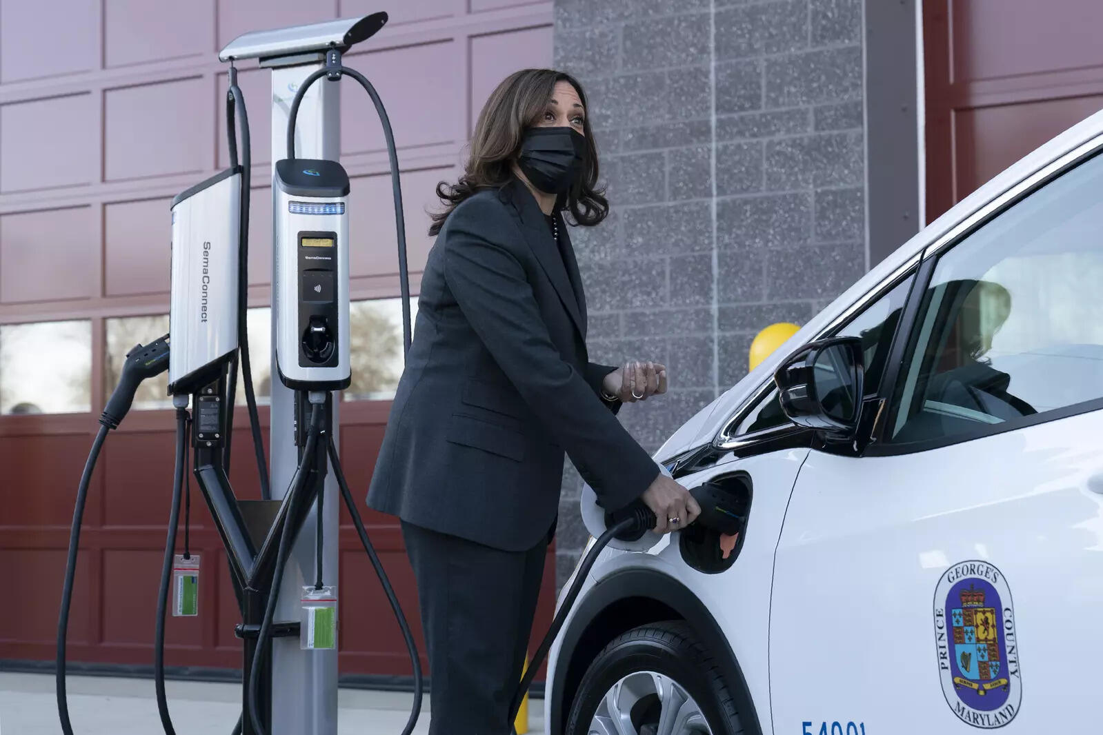 Vice President Kamala Harris charges an electric vehicle in one of the charging stations during her tour of the Brandywine Maintenance Facility in Prince George's County, Md., highlighting the electric vehicle investments in the bipartisan infrastructure law and the &quot;Build Back Better Act&quot; Monday, Dec. 13, 2021. (AP Photo/Manuel Balce Ceneta)