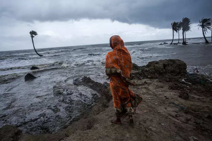  A woman is standing in front of her house which is under water due to tidal flood in Mousuni island, Sundarbans. (Image credit: Supratim Bhattacharjee) 