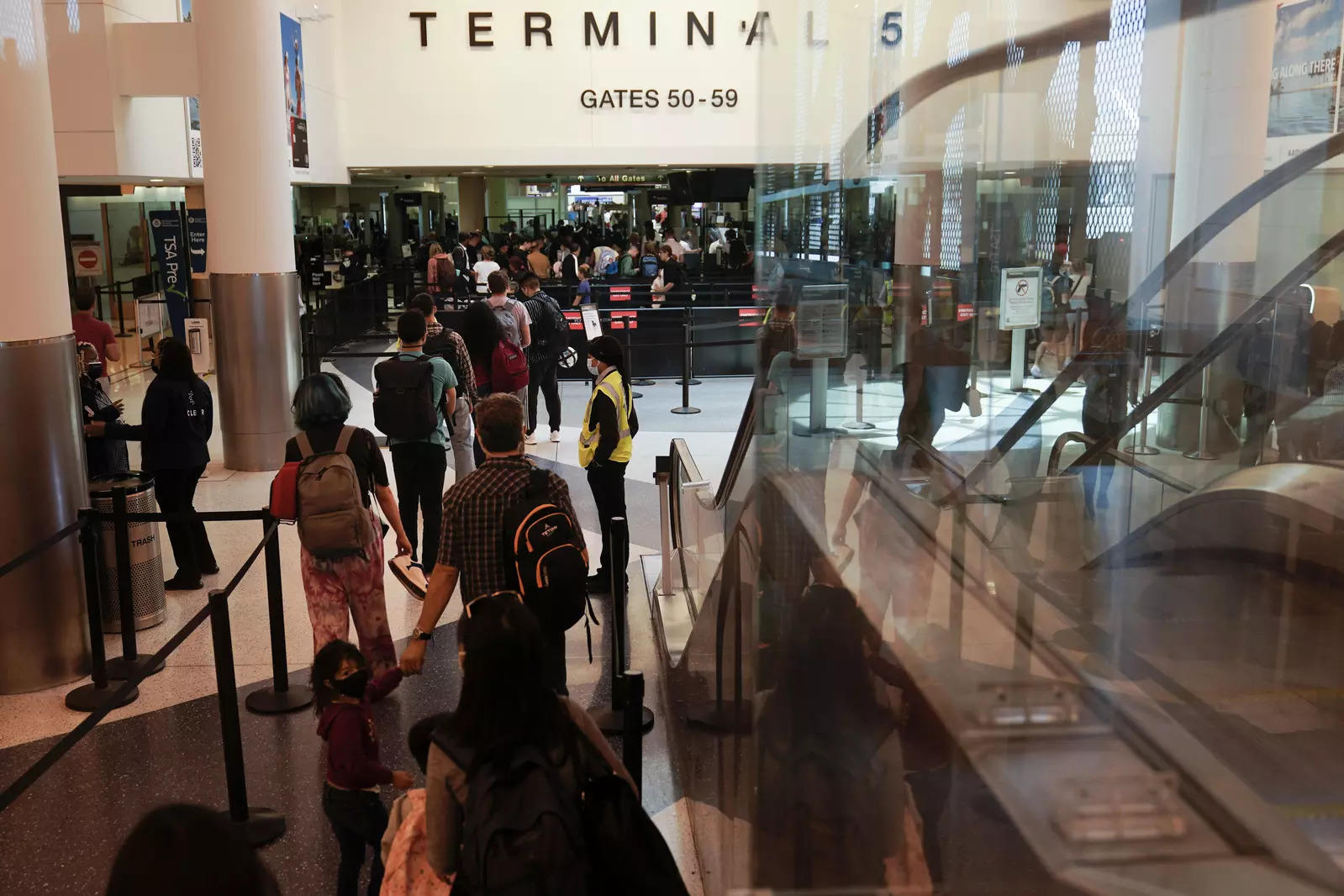   Travelers wait in for a TSA security check at the Los Angeles International Airport in Los Angeles, Friday, July 1, 2022. The July Fourth holiday weekend is off to a booming start with airport crowds crushing the numbers seen in 2019, before the pandemic.  (AP Photo/Jae C. Hong)
