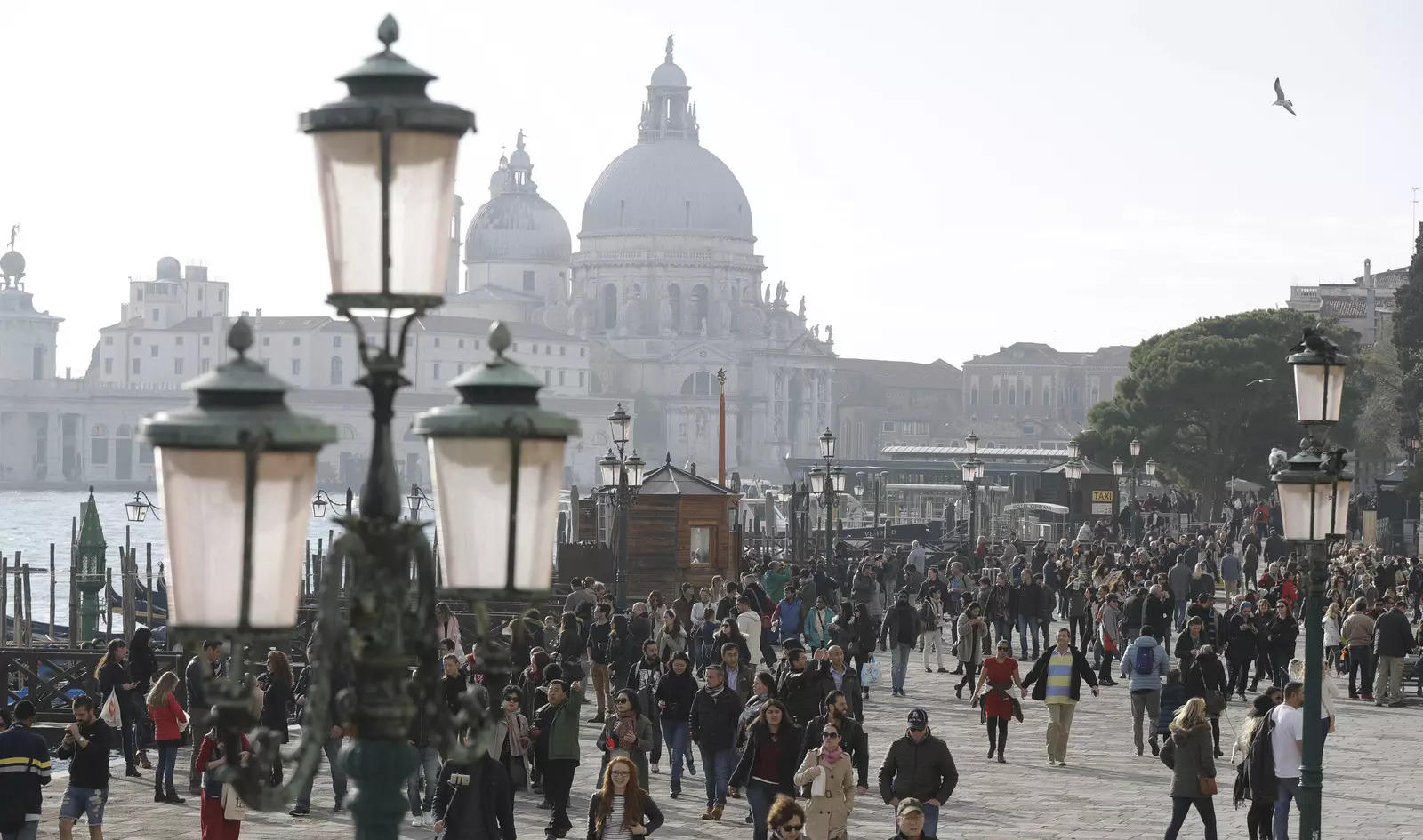   Tourists stroll in downtown Venice, Italy, Nov.  12, 2016. Starting in January, Venice will oblige day-trippers to make reservations and pay a fee to visit the historic lagoon city.  On many days, the heart of Venice is overwhelmed by visitors, who often far outnumber residents.  Venice officials on Friday unveiled new rules for day-trippers, which go into effect on Jan.  16, 2023.