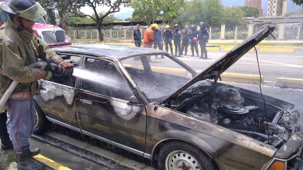     Un bombero apaga un incendio que se desató en un auto en Maracay, Venezuela 