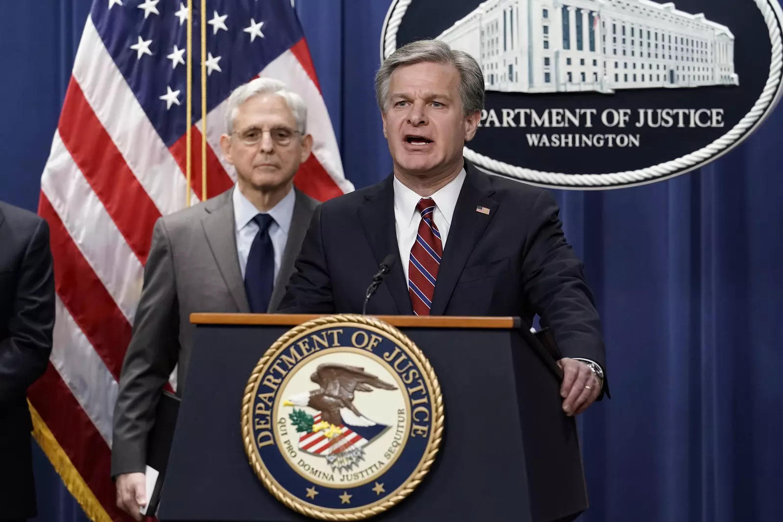  FBI Director Christopher Wray, joined at left by Attorney General Merrick Garland, speaks to reporters as they announce charges against two men suspected of being Chinese intelligence officers for attempting to obstruct a U.S. criminal investigation and prosecution of Chinese tech giant Huawei, at the Department of Justice in Washington, Monday, Oct. 23, 2022. (AP Photo/J. Scott Applewhite)
