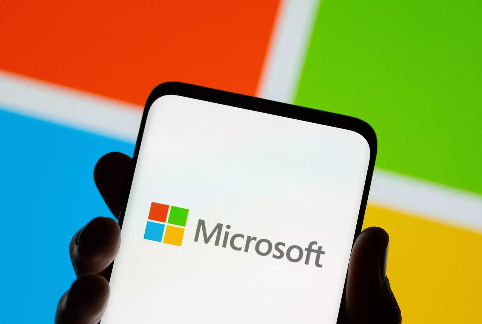     A smartphone is seen in front of the Microsoft logo in this illustration taken on July 26, 2021.  REUTERS/Dado Ruvic/Illustration