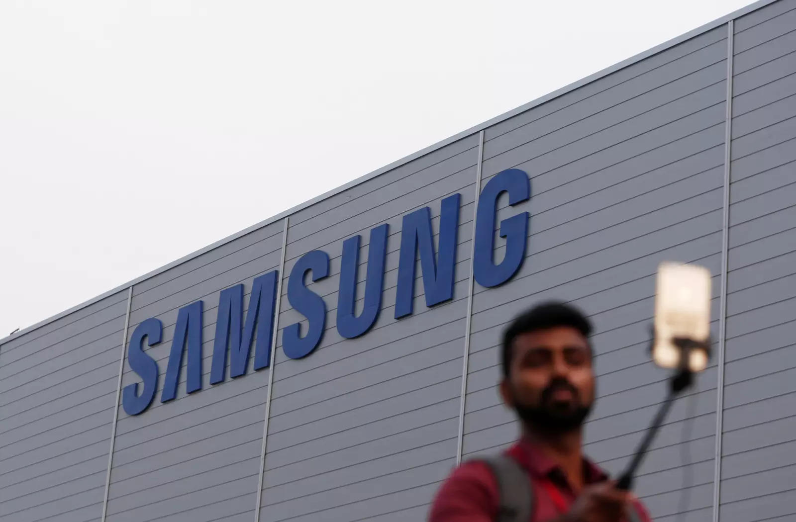  FILE PHOTO: A journalist uses a mobile phone as he works outside the Samsung Electronics smartphone manufacturing facility in Noida, India, July 9, 2018. REUTERS/Adnan Abidi
