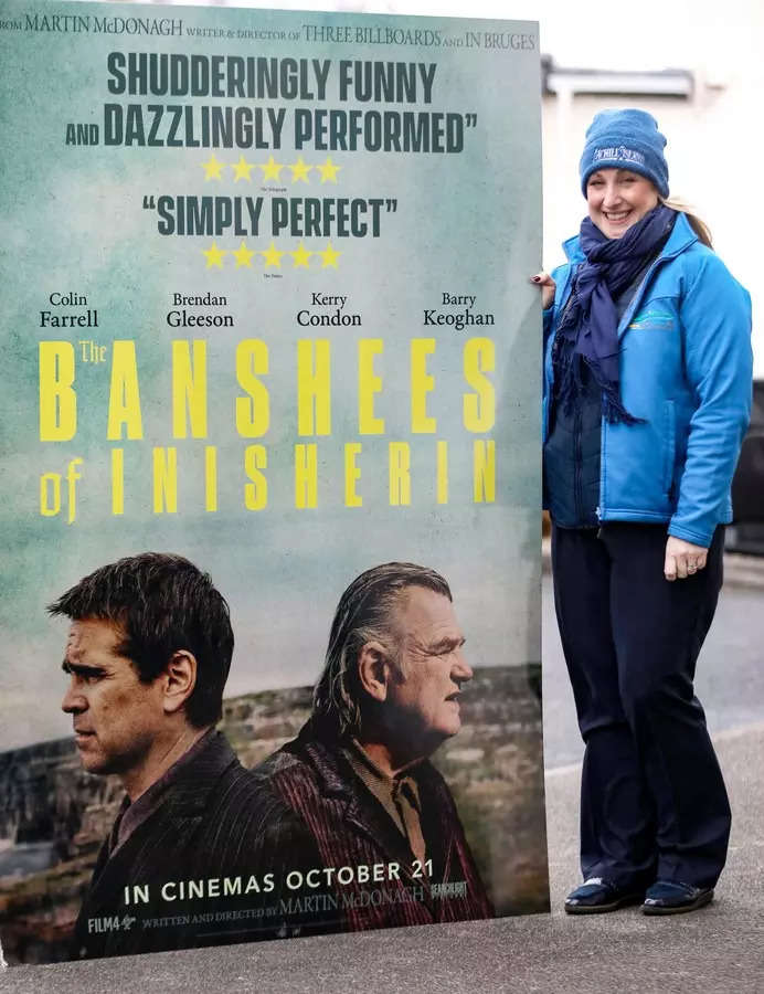 <p>An employee of the Achill Island Tourism officer poses with a poster of the film "The Banshees of Inisherin", on the Achill Island, on January 31, 2023, off the west coast of Ireland. Among those whom he thanked by receiving a Golden Globe for his role in "The Banshees of Inisherin", Colin Farrell cited the inhabitants of Achill Island and Inis Mor, Irish islands who already benefit from the exposure offered by the movie. (Photo by Paul Faith / AFP)</p>