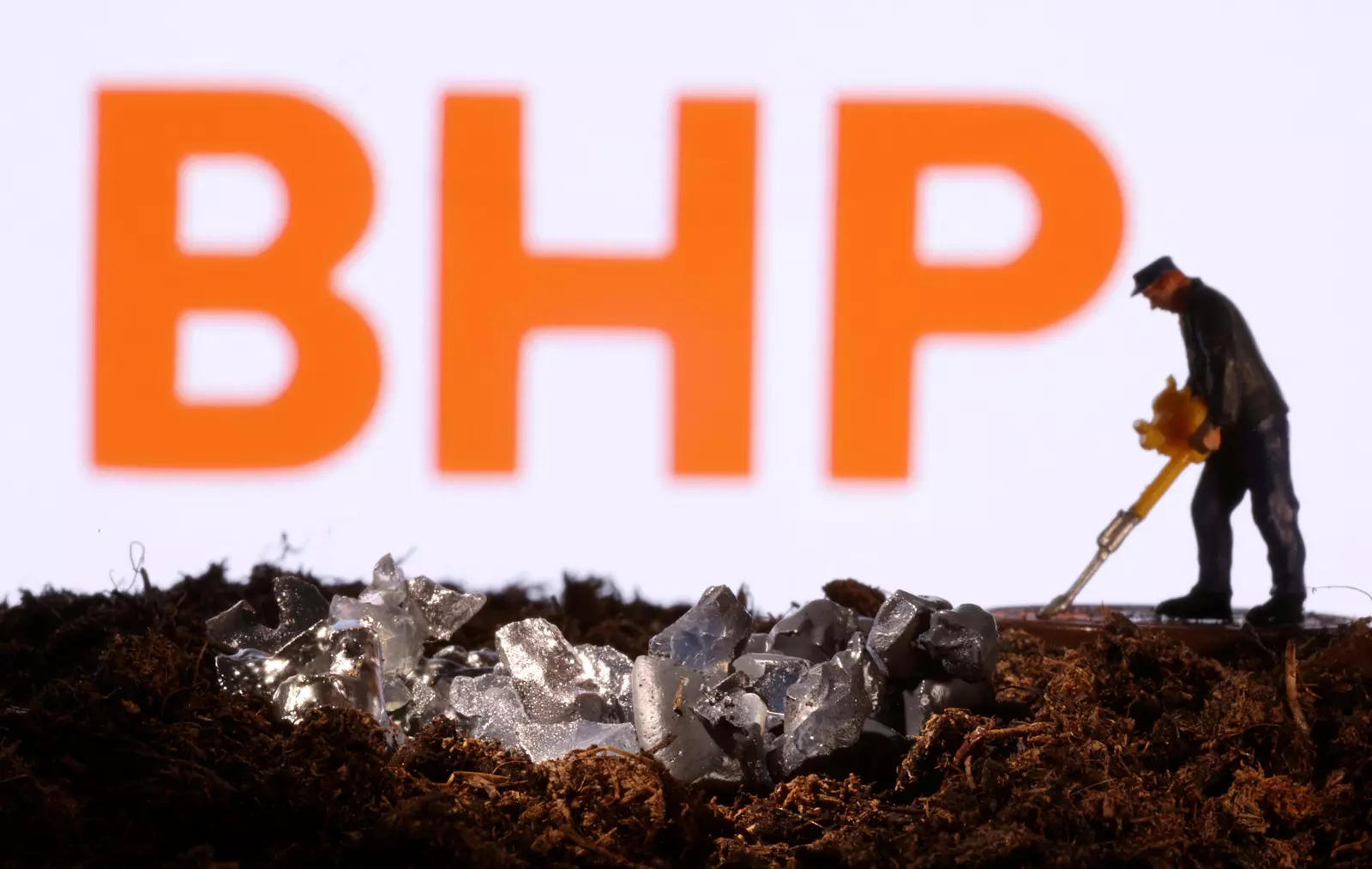  FILE PHOTO: A small toy figure and mineral imitation are seen in front of the BHP logo in this illustration taken November 19, 2021. REUTERS/Dado Ruvic/Illustration/File Photo
